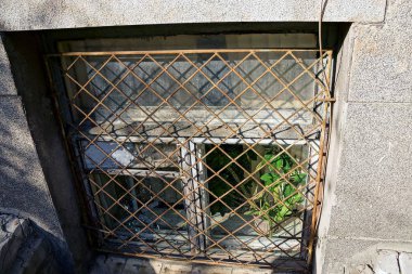 Bodrum katında duvardaki bir kafes ile eski kirli pencere