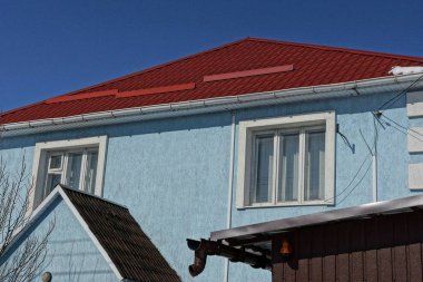 mavi duvar kırmızı çatılı bir evin üstünde pencere eşiği