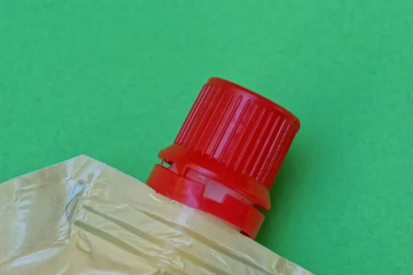 Частина Пластикового Пакету Покритого Червоною Кришкою Зеленому Фоні — стокове фото
