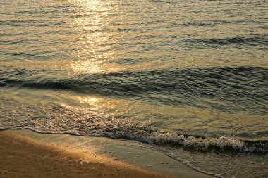 dalgalar deniz ve güneş ışığı bir yaz akşamı ile sahilde kum