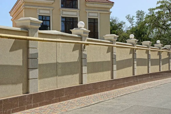 bir evin yakınındaki bir asfalt yol sokakta önünde kahverengi Beton çit