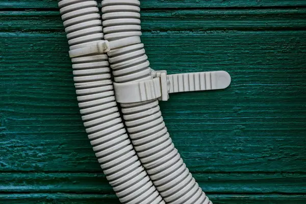 绿色木屋墙上的灰色塑料绝缘电缆 — 图库照片