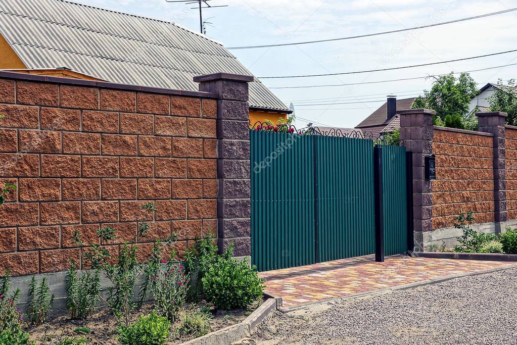 The green gate and the gate of iron and the brick brown fence