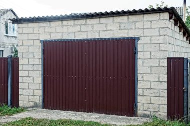 özel tuğla garaj yeşil çim Caddesi üzerinde kahverengi demir kapaklı