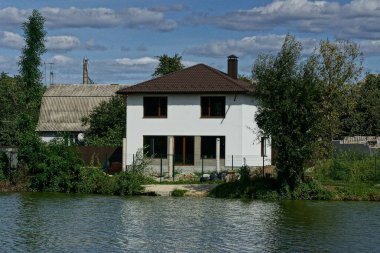 baraj gölünün kıyısında suya yakın penceresi olan büyük özel beyaz ev