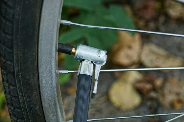 在自行车车轮的奶嘴上有软管的部分泵 — 图库照片