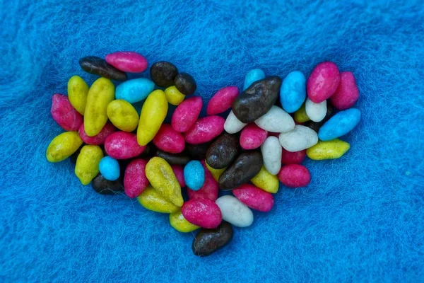 Ein Haufen Kleiner Farbiger Bonbons Herzform Auf Blauem Wolltuch — Stockfoto