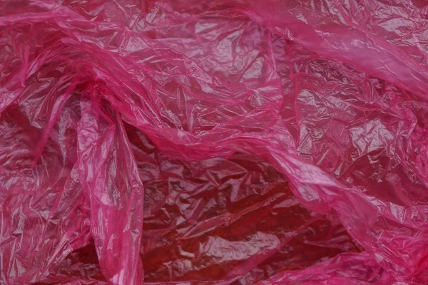 Plastic texture of a piece of crumpled red bright cellophane