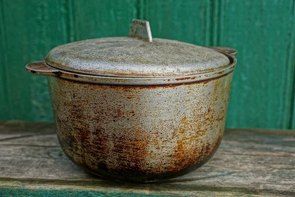 Velho Cinza Queimado Panela Uma Mesa Pela Parede Verde — Fotografia de Stock