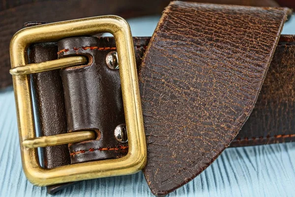 Parte Cinturón Marrón Con Una Hebilla Cobre Una Mesa Azul — Foto de Stock