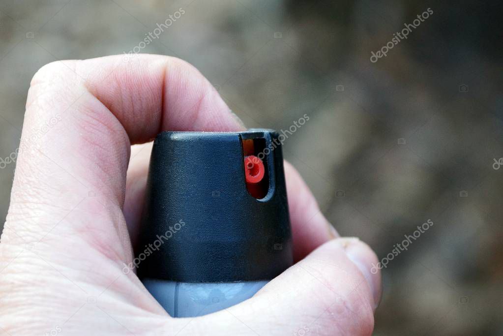 Gas bottle in hand with finger on button