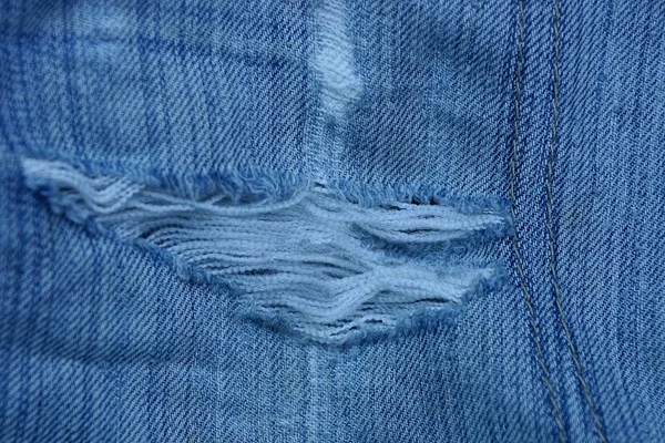 Ein Stück Blaue Jeanshose Mit Weißen Fäden Auf Zerrissenem Stoff — Stockfoto