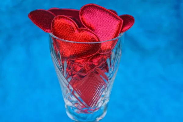 Glas Transparenter Kelch Voller Roter Herzen Auf Blauem Hintergrund — Stockfoto