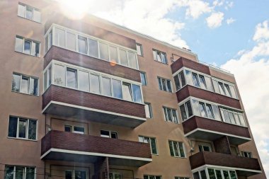 Kahverengi bir evin balkon ve gökyüzü güneş ışığı altında windows
