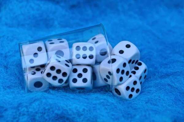 在蓝色羊毛织物上的白色骰子透明塑料杯 — 图库照片