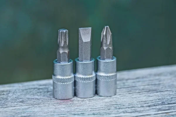 Drie Grijze Metalen Bits Voor Een Schroevendraaier Een Grijze Houten — Stockfoto