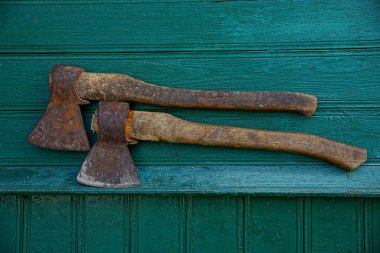 İki demir paslı balta, yeşil ahşap wal