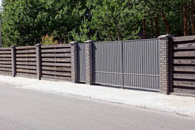 Gri kahverengi kapı ve bir çit önünde bir asfalt yol