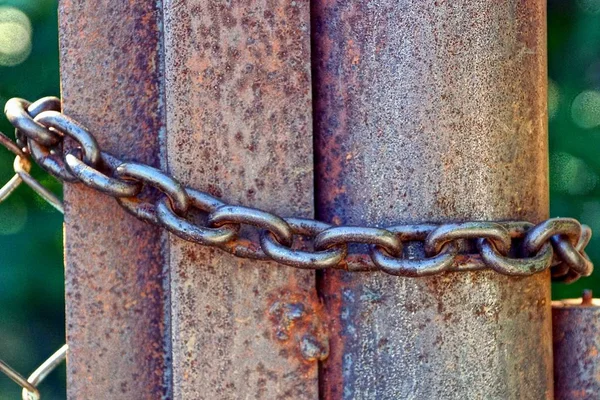 フェンスの上の茶色のさびた鉄パイプとスチール チェーン — ストック写真