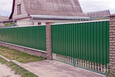 Metal geçit yeşil ve çit sokakta parçası kapalı