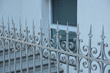 çit parçası keskin bir pencere ile evin duvarına karşı çelik çubuklar