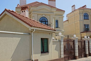 mavi gökyüzü parmaklığa arkasında penceresi olan kahverengi bir özel ev cephe