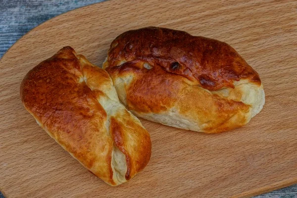 Zwei Braune Gebratene Pasteten Liegen Auf Einem Holzbrett — Stockfoto