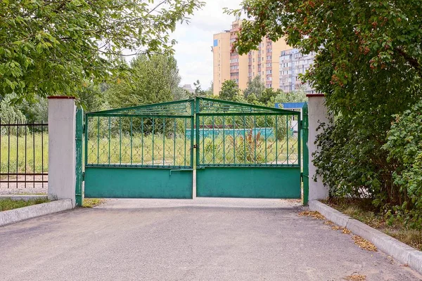 Grünes Eisentor Und Zaun Grüner Vegetation Auf Einer Asphaltierten Straße — Stockfoto