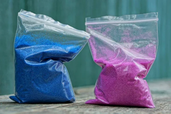 Дві Пластикові Сумки Синім Червоним Піском Столі — стокове фото