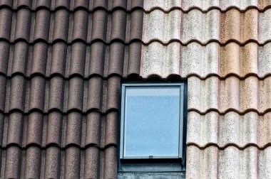 Gri kahverengi kiremit ve binanın çatısında bir cam pencere