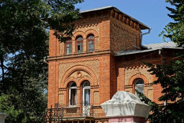 Gökyüzüne karşı yeşil dallar arasında kule inşa kahverengi eski tuğla