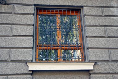 bir siyah demir ızgara gri beton duvara arkasındaki kahverengi pencere