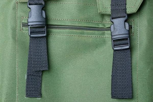 グリーン生地のバックパックのハーネスに つの黒いプラスチック カービン銃 — ストック写真