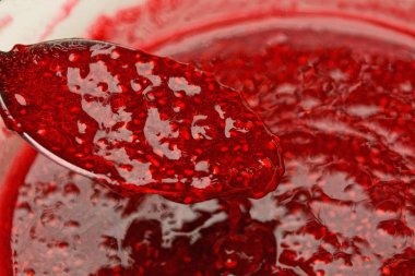 Kaşık ile bir tabak içinde kırmızı ahududu reçeli