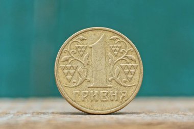 bir yuvarlak sarı Ukraynalı hryvnia sikke üzerinde yeşil bir arka plan üzerinde gri bir tablo