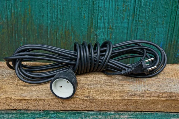 Black Extension Cord Hank Lies Brown Wooden Board Green Wall — Stock Photo, Image