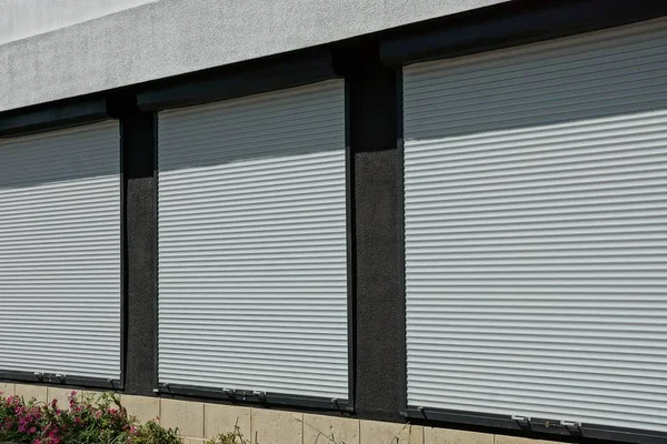 Trzy Okna Pokryte Białe Plastikowe Okiennice Ścianie Domu — Zdjęcie stockowe