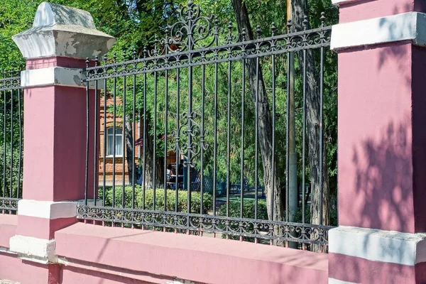 ピンクのコンクリート フェンスと鍛造パターンで鉄の棒の部分 — ストック写真