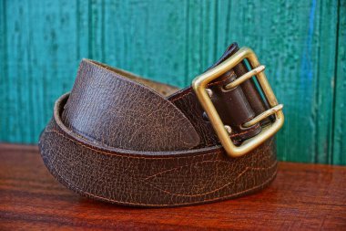 Yeşil kurullarında bakır bir toka ile kahverengi deri kemer