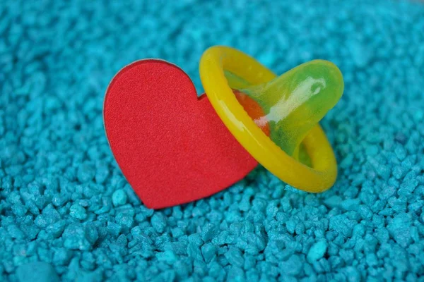 Coração Vermelho Preservativo Amarelo Areia Fina Azul — Fotografia de Stock