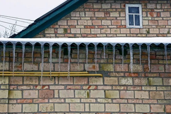 Icicles Από Μια Στέγη Ένα Τοίχο Από Τούβλα Ένα Παράθυρο — Φωτογραφία Αρχείου