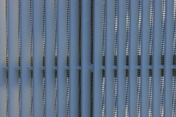 Grauer Hintergrund Langer Kunststoffstäbe Auf Dem Gitter — Stockfoto