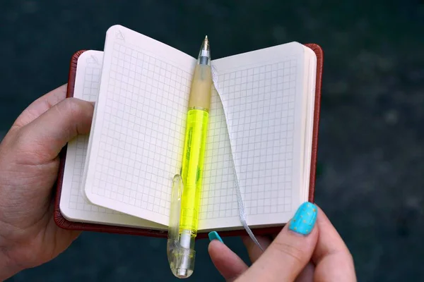 Caderno Branco Aberto Uma Caneta Verde Nas Mãos Uma Menina — Fotografia de Stock