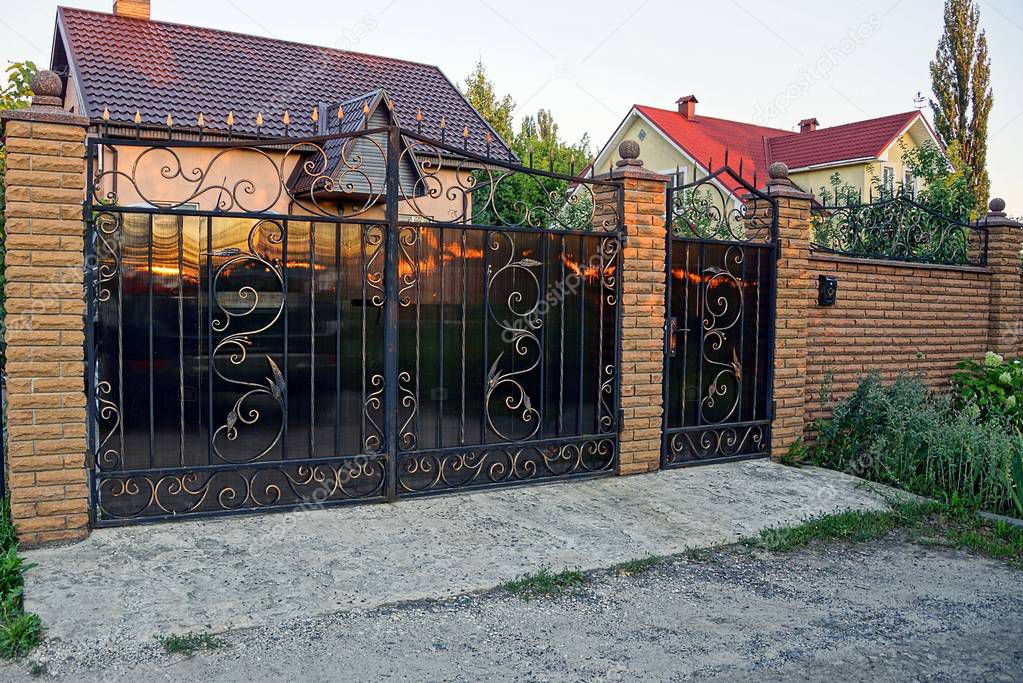 Closed brown gates on a brick fence