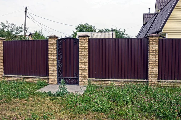 Long Brown Fence Closed Door Metal Brick Green Grass — Stock Photo, Image