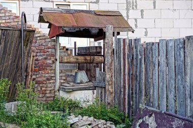 Eski bir zincir yakınındaki bir tuğla duvar üzerine bir kova ile iyi