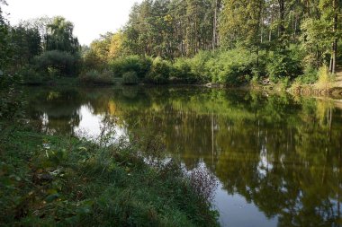 Yatay, yeşil ağaçlar ve büyük bir rezervuar