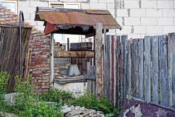 Old Sumur Dengan Ember Pada Rantai Dekat Dinding Bata — Stok Foto