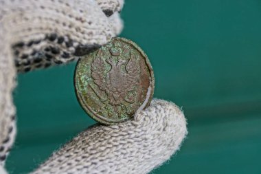 old green russian coin with an eagle in the fingers clipart