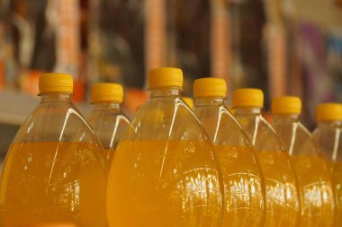 bir satır sarı içki ile kapalı plastik şişe